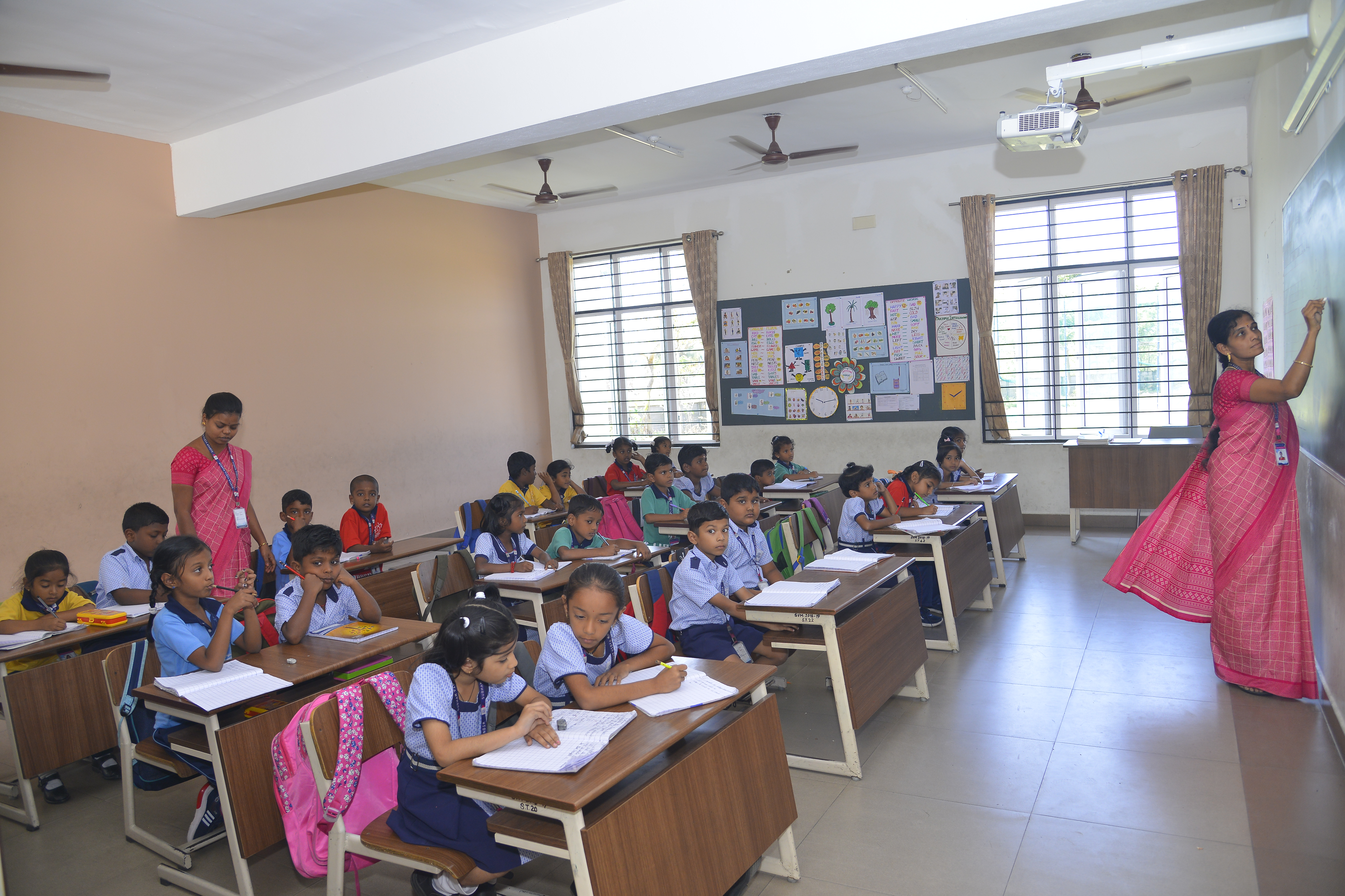 Happy Subham Vidyashram School boy child seated in a classroom looking up and smiling.